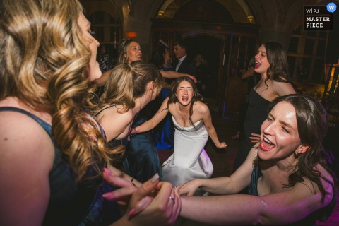   On the dance floor at Waterford Castle, the bride is framed by her friends as they dance together, filling the historic Irish venue with joy and celebration.