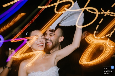   Friends join the newlyweds for lively dancing at the Istanbul Four Seasons Hotel, the group sharing laughter and energetic moves captured with a slow shutter. 