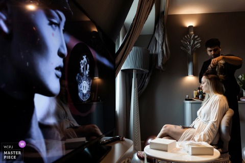   At Wyndham Grand Kalamis in Istanbul, the bride prepares for her wedding day, surrounded by elegant decor, a TV, and the anticipation of the celebration ahead.