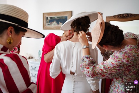 Family Love Radiates As Bride’s Sisters And Mother Finish Her Hairstyle At Home In Paladru, Isère, Before Ceremony. At the bride’s house in Paladru, Isère, the bride’s sisters and mother make final adjustments to her hairstyle, sharing a warm and intimate family moment before the ceremony.