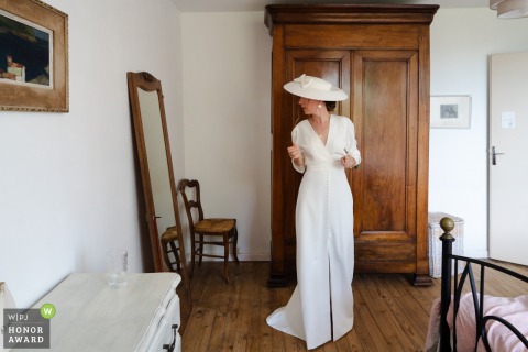 At Her Home In Paladru, France, The Bride Shares A Thoughtful Last Look At Her Wedding Dress In A Mirror At her home in Paladru, France, the bride takes one final, thoughtful look at her wedding dress before departing for the church ceremony.