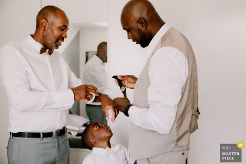   At Sologne in Centre-Val de Loire, fine wedding details are put on groom's wrist and photographed, highlighting the thoughtful touches that contribute to the feeling of the day.
