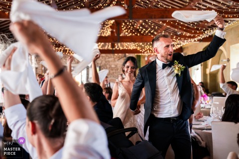   In Udine, Italy, the bride and groom make their grand entrance into the dinner room as all the guests enthusiastically wave their napkins to celebrate the couple.