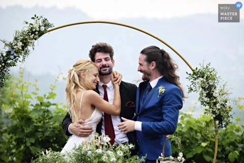 Warm Hugs And Tears Follow A Touching Speech As Bride Embraces The Best Man At Ghisolfa Farmhouse In Lecco, Italy. At Ghisolfa Farmhouse in Lecco, Italy, the bride embraces the groom’s best man after his touching speech during the ceremony, sharing a heartfelt moment witnessed by emotional guests.