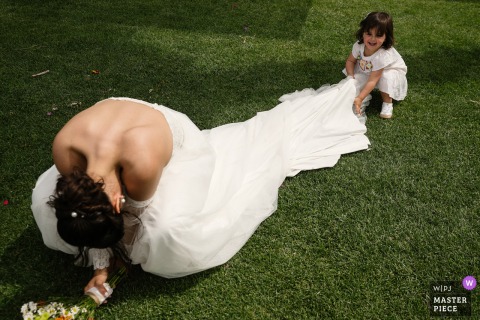   The bride enjoys a lighthearted and joyful moment with her daughter at a reception venue in Lisbon, Portugal, highlighting their special bond during the wedding festivities.