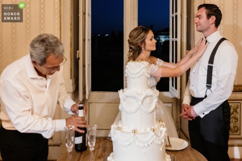Moments before the cake cutting at a Lisbon reception venue, the bride lovingly adjusts the groom’s bow tie, ensuring he looks perfect for this special part of the evening.