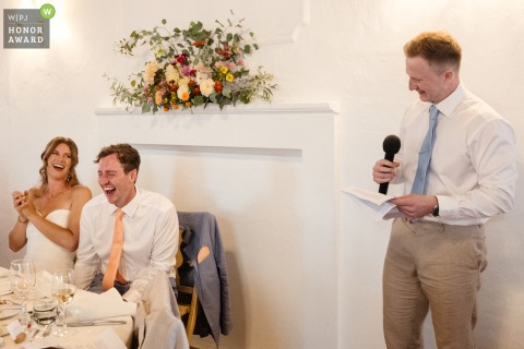 The best man stands at the reception venue in Lisbon, delivering a heartfelt speech to the wedding guests, sharing memories and laughter with the couple.