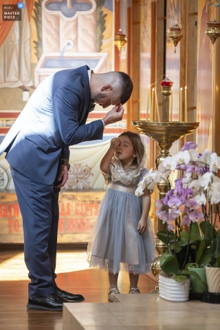 In A Central Coast Church, A Child Learns Catholic Traditions And Family Heritage During The Wedding Service. In a church on the Central Coast, a child attentively learns the traditions of the Catholic church, participating in family heritage and faith during the wedding service.