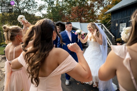   In Gatlinburg, Tennessee, the bride radiates incredible excitement as the couple is joyously surrounded by their supportive groomsmen and bridesmaid during their special wedding celebration.