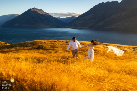 On the mountainside at Jack's Point in Queenstown, New Zealand, Cassie’s veil blows free in a fierce gust, and the landscape itself seems to join the ceremony with unruly elegance.