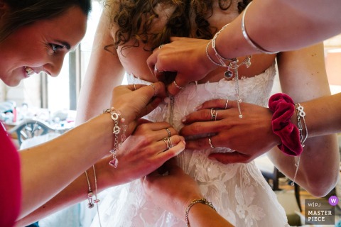 Inside the London hotel, the bride’s three sisters button her dress with careful hands, and the dressing room becomes a small, affectionate workshop of kinship and nerves.