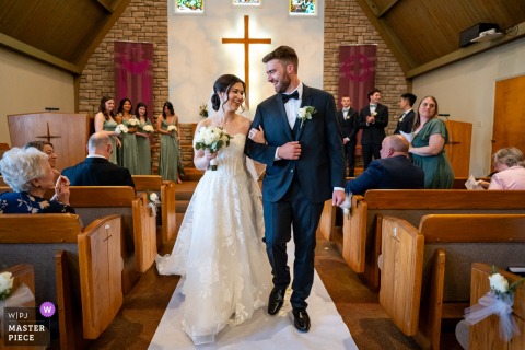 Leaving Shepherd of the Hills Lutheran Church, the happy bride and groom walk down the aisle as husband and wife, their steps carrying relief, ceremony, and a new public identity.