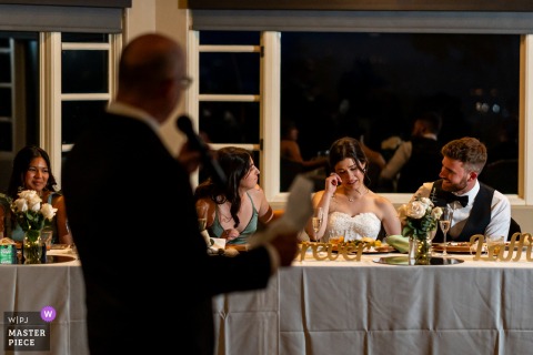 While her father speaks at The Heights Golf Club in San Diego, California, the bride cries during the toast, her face carrying the day’s tenderness and history.