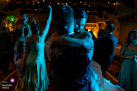 As the last song ends at The Heights Golf Club in San Diego, California, the bride jumps into her husband’s arms, closing the night with joyful momentum.