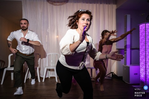 At Le Clos Vernay In Isère, France, Guests Join A Running Game At The Wedding Reception Party At Le Clos Vernay in Isère, France, wedding guests join a running game at the party, their playful competition loosening the room and turning the celebration into lively theater.