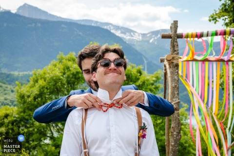 At La Tuile Aux Loups In Corps, France, A Bowtie Is Fixed Before The Ceremony At La tuile aux loups in Corps, France, the laic ceremony begins with stillness, help with a bowtie, attention, and the feeling of something about to deepen.