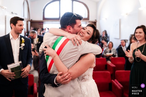 In Trieste, Italy, the celebrant, also the bride’s best friend, hugs the newlyweds at the end of the ceremony, sealing the day with friendship, relief, and affection.