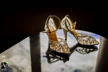 At Mersin Hilton Hotel, the bride's shoes are elegantly displayed, their image reflected on the glass surface. This detail shot captures the sparkle and style of the wedding shoes.