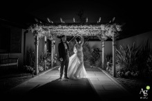 A black and white photograph captures a bride and groom, backlit, during their first dance at The Redhurst Hotel