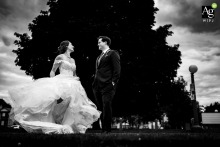 In a quiet park in Toronto, Ontario, the bride lifts and sways her dress, the fabric catching the light and adding motion to her portrait among the greenery.