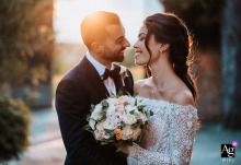 At Villa Bria in Gassino Torinese, the bride and groom face each other with the low sun behind them, capturing a serene wedding scene at the historic venue.