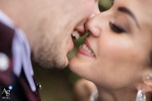 A close-up of a couple's joyful, kissing smiles, captured at Tenuta La Michelina, Torino, Italy.