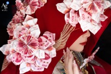Bride in Fujian, China, wears traditional wedding attire with money origami head covering, celebrating customs.