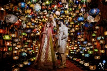 Bride and groom pose romantically among glowing lamps in a vibrant lamp store, Süleymaniye, Istanbul.