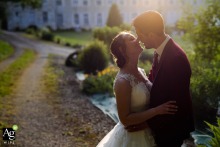 Bathed in the warm, golden glow of sunset at a reception venue in Poitiers, France, the couple shares a gentle and soft embrace for a romantic evening wedding portrait.