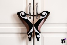 Bridal shoes are creatively arranged to form a butterfly design, with their heels hanging on cabinet pulls in Trieste, Italy.