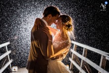A romantic, backlit shot of the couple in the rain without an umbrella at Kasteel Duurstede wedding venue.