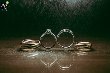 Delicate wedding rings rest in the rain against a textured surface in Taipei, Taiwan, where water droplets add a moody and artistic element to this quiet still-life detail.