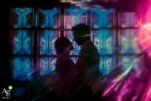A silhouette of a couple is cast against colorful stained glass at The Loft at Lena’s in Alexandria, Virginia, accented by a soft and artistic lens flare.