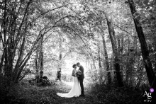 Symmetrical Black And White Forest Portrait With Tree Canopy At Bonneuil Matours France Bonneuil Matours, France — The couple poses in the Moulière forest for a symmetrical black-and-white portrait, with the arching canopy of trees creating a dramatic and natural overhead frame.