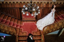 Sait Halim Paşa Yalısı, Istanbul — In a symmetrical wedding day portrait, the bride ascends the stairs while the groom walks down and away, positioned lower and center in the frame, creating a dynamic and artistic image at the historic waterfront mansion.