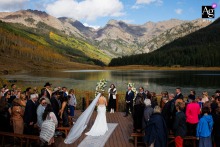 Piney River Ranch provides a stunning mountain backdrop as the bride, an artistic focal point, begins her walk down the aisle during her memorable wedding ceremony.