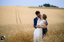 Toulouse, Haute-Garonne — The bride and groom share a kiss in a wheat field near the reception venue, captured in a minimalist, simple, and clean wedding portrait surrounded by open countryside.