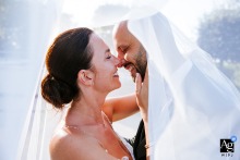 Chateau de Larraldia — The couple embraces closely under the bride’s sweeping veil in a tight shot, about to kiss, creating an intimate and romantic wedding portrait at the château.