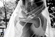 Divan Istanbul — The couple laughs together, enveloped by the bride’s sweeping veil in a tight black-and-white shot, capturing warm love and intimacy in this artistic wedding portrait.
