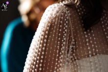 An abstract photographic detail captured at the Crown and Thistle, Abingdon, England, showcases the unique patterning and delicate beading found on the bride's bespoke white wedding dress.
