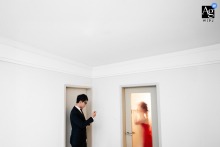   At home in Taiyuan, Shanxi, the groom fastens his buttons while the bride applies lipstick, each preparing for their wedding in a quiet, shared moment.