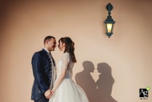 Couple Portrait Features Shadows on Wall at La Casina Rossa Events in Perugia Umbria Italy A couple portrait is taken at La Casina Rossa Events in Perugia, Umbria, Italy, showing the pair together with their shadows on a wall as a backdrop.