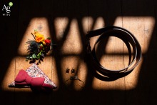 At Château de Launac in Haute-Garonne, wedding accessories belonging to the groom are arranged and lit to display their style and significance.