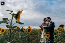   At Domaine in Indre, the wedding couple stands together amid a field of sunflowers, the golden blooms creating a picturesque natural backdrop for their portrait.