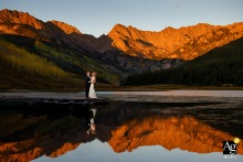 Bride and groom pose together on a dock at Piney Lake during alpenglow at Piney River Ranch.