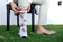   In Grenoble, France, a close-up reveals the groom’s cheerful and colorful socks, adding a playful detail to his wedding attire.