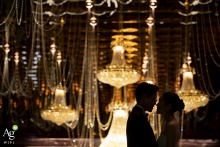 A silhouetted couple stands together at Asia Hotel in Bangkok, their outlines set against a softly lit backdrop, highlighting romance and anticipation before the celebration.