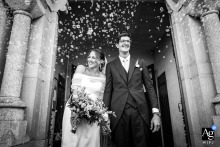   In Marly-sur-Arroux, guests and newlyweds exit the church following the ceremony, the crowd and historic architecture contributing to this classic wedding scene.