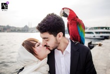 Couple Poses With Vibrant Parrot During Unique Karaköy Istanbul City Portrait In Karaköy, Istanbul, the couple poses with a vibrant parrot borrowed from a local trainer, offering a unique and lively visual element to their city portrait session.