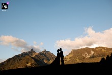 In Fribourg, the bride and groom appear as silhouettes at the reception venue, with a breathtaking mountain backdrop, bringing a dramatic sense of place and scale to their portrait.
